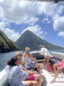A lively group enjoys a boat ride with stunning mountain scenery in the background, perfect for adventure seekers and scenic tours.