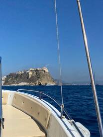 A scenic view from a boat showcasing a beautiful coastline and island in the background, perfect for exploring picturesque destinations on the water.