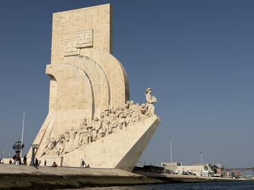 A view of a prominent monument with people gathered nearby, showcasing historical significance and architectural beauty.
