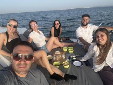 A cheerful group enjoys a delightful meal on the deck of a yacht, perfect for celebrations and gatherings on the water.