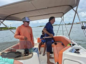 Inside view of a boat's cabin with guests preparing for an adventure on the water. The comfortable seating and helm area set the stage for a fun day out.