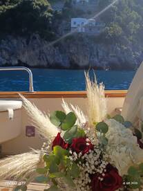 A beautifully arranged bouquet of roses and greenery on a boat, perfect for romantic occasions or celebrations on the water.