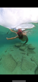 A snorkeler explores underwater rock formations in crystal-clear waters, showcasing the beauty of marine life and adventure activities.