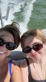 A joyful selfie of two individuals enjoying a boat ride, capturing the fun and excitement of their day on the water.