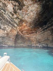 A stunning view of a natural cave with vibrant turquoise waters, perfect for exploring hidden gems during a boating adventure.