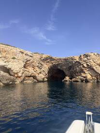 A stunning view of a rocky coastline featuring a natural cave, perfect for exploring the beauty of coastal landscapes while boating.