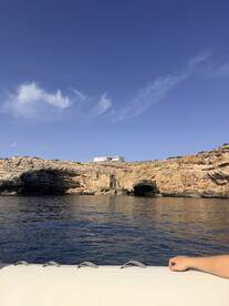 A scenic view from a boat showcasing a stunning coastline with a cave, perfect for exploring natural wonders and enjoying the beauty of the sea.