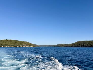 A stunning view of the coastline and clear blue waters, showcasing the natural beauty of the area — perfect for scenic boat trips and exploration.