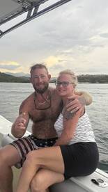 A happy couple enjoys their time together on a boat, capturing a joyful moment amidst scenic waters — perfect for romantic getaways or special celebrations.