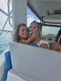 A joyful moment captured on a boat, featuring a smiling mother holding her baby, showcasing the fun and bonding experiences families can enjoy on the water.