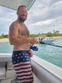 A man enjoys a fishing trip on a boat, showcasing the thrill of angling in beautiful ocean waters.