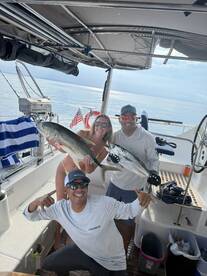 A joyful group celebrates their successful fishing trip aboard a boat, showcasing their impressive catch — a perfect moment for fishing enthusiasts.