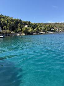 A stunning view of a serene coastline with turquoise waters and lush greenery, perfect for a relaxing day on the water.