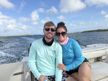 A happy couple enjoys a boat ride, capturing a moment of joy on the water — perfect for romantic getaways or adventure-filled days at sea.