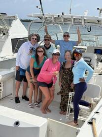A cheerful group of friends poses for a fun photo aboard a boat, capturing the joy of their day on the water.