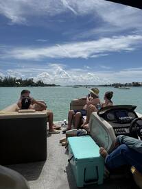 A group of friends enjoys a relaxing day on a pontoon boat, soaking up the sun and the beautiful water views — perfect for summer outings.