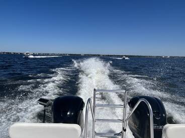 A dynamic view of a boat speeding through the water, showcasing the excitement of a day on the water with a scenic backdrop.