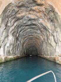 A stunning view of a boat navigating through a natural cave, showcasing the unique rock formations and crystal-clear waters — an unforgettable adventure in nature.