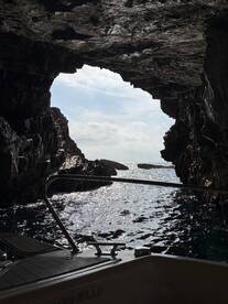 A stunning view from inside a cave looking out towards the ocean, showcasing the natural beauty of coastal landscapes — perfect for adventure seekers exploring hidden gems by boat.