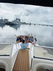 A lively group of friends celebrates aboard a boat, capturing memories with smiles and waves — perfect for unforgettable outings on the water.