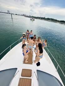 A lively group of friends enjoys a fun day on the boat, celebrating and socializing in stylish bikinis — perfect for summer parties on the water.