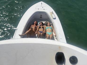 A group of friends relaxes on the deck of a boat, enjoying the sun and water — perfect for a day of leisure on the water.