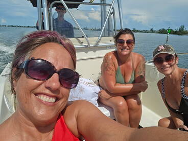 A cheerful group of friends enjoys a day on the water, capturing the moment with smiles and laughter aboard their boat.