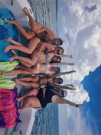 A joyful group of friends poses on a boat, celebrating their day on the water with smiles and fun — perfect for summer outings and memorable adventures.