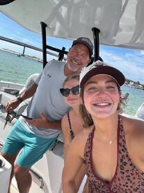 A cheerful group takes a selfie aboard a boat, capturing a fun moment on the water — perfect for memorable outings and adventures.