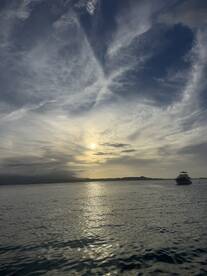 A serene sunset view featuring a boat anchored in calm waters, creating a picturesque backdrop perfect for evening cruises.