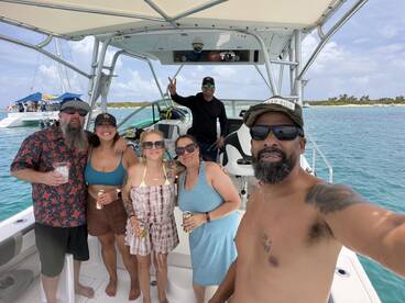 A lively group enjoys drinks aboard a boat, capturing the essence of a fun day on the water with friends and celebration.