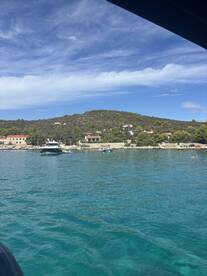 A picturesque view of a serene coastline with boats anchored in clear waters, perfect for exploring the beauty of the area.