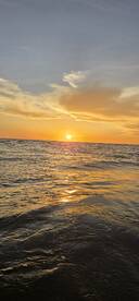 A serene sunset over the ocean, reflecting golden hues on the water's surface — a perfect backdrop for peaceful boating experiences.
