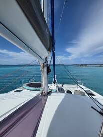 A stunning view of a catamaran sailing through crystal-clear waters, showcasing its sleek design and vibrant surroundings — perfect for sailing enthusiasts and adventure seekers.
