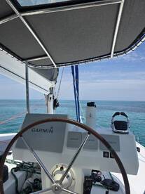 A detailed view of the helm area on a sailboat, showcasing the steering wheel and navigation equipment, perfect for those interested in sailing adventures.