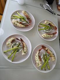 Deliciously prepared lobster with asparagus and rice served on elegant plates, perfect for a gourmet dining experience aboard a boat.