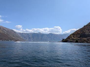 A picturesque view of boats navigating through a stunning mountainous coastline, showcasing the natural beauty of the area — perfect for boating adventures.