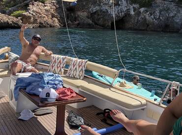 Guests enjoy a lively boat party, relaxing on deck and swimming in the clear waters — a perfect day for fun and celebration on the water.