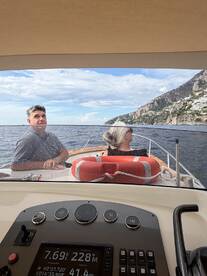 A couple enjoys a scenic boat ride along a stunning coastline, capturing the essence of adventure on the water.