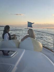 Two guests enjoy a serene sunset on a boat, creating a perfect backdrop for relaxation and memorable moments on the water.