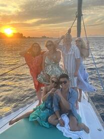 A joyful group of friends celebrates at sunset aboard a yacht, capturing a heartwarming moment against a stunning backdrop — perfect for memorable gatherings on the water.
