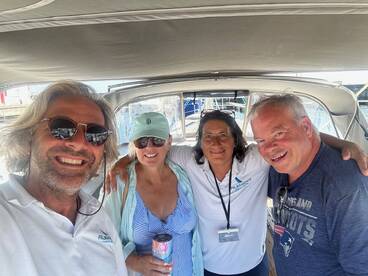 A cheerful group of friends poses for a selfie aboard a boat, capturing the joy of their maritime adventure together.