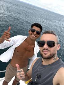 Two friends pose for a cheerful selfie on a yacht, showcasing their fun day on the water. Perfect for capturing memorable moments during a boating adventure.