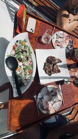 A beautifully arranged meal featuring fresh salad and grilled meat, perfect for enjoying on a boat. Ideal for catering and dining experiences at sea.