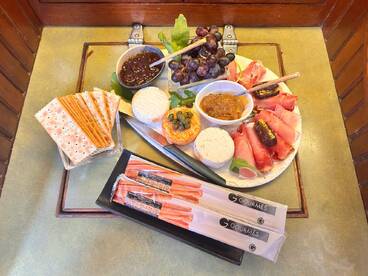 A beautifully arranged charcuterie platter featuring a variety of meats, cheeses, and fruits, perfect for enjoying onboard during a relaxing cruise.