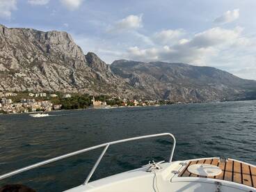 A scenic view from a boat showcasing the stunning coastline and mountains, perfect for exploring the natural beauty of the area.