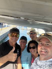 A cheerful group of friends poses for a selfie aboard a boat, capturing the joy of their maritime adventure together.