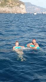 A couple enjoys a refreshing swim in the ocean, showcasing a perfect day of fun and relaxation on the water.