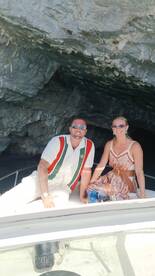 A couple enjoys their time on a boat, capturing a moment of joy and relaxation in a scenic location.