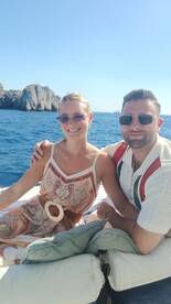 A couple enjoys a sunny day on a boat, surrounded by stunning ocean views — perfect for romantic getaways or memorable adventures on the water.